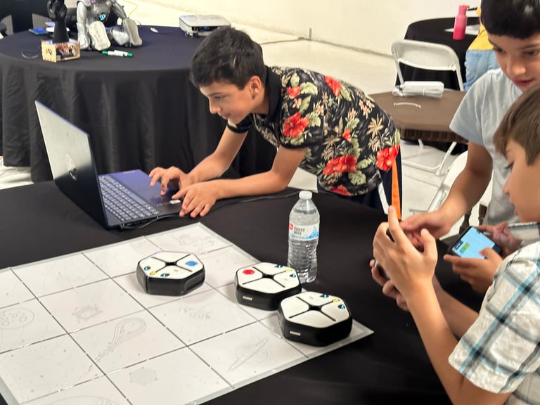 Man in floral shirt operating robot on white grid floor during workshop demonstration with children observing
